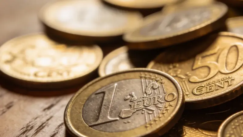 Drobné euromince rozsypané na stole