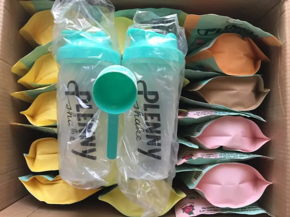 Otvorené balenie JimmyJoy zásielky s dvoma šejkrami, odmerkou a farebnými vreckami Plenny Shake