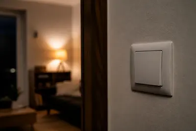 Vypínač a teplé svetlo lampy v byte.