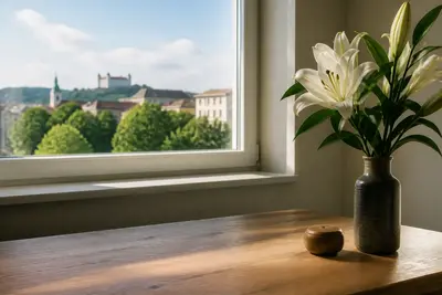 Biele ľalie vo váze pri okne.
