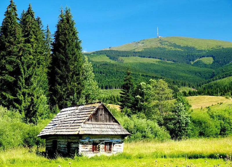 Pohľad na obec Šumiac s lúkami a kopcami v pozadí