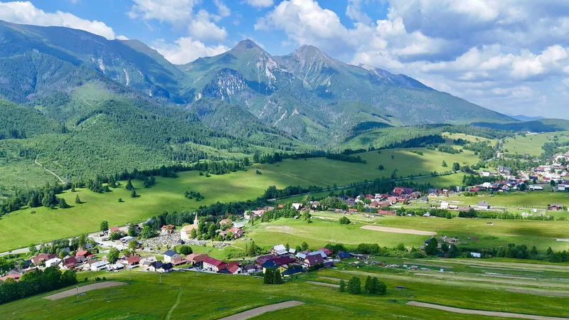 Pestro maľované drevené domy v Ždiari s Belianskymi Tatrami v pozadí
